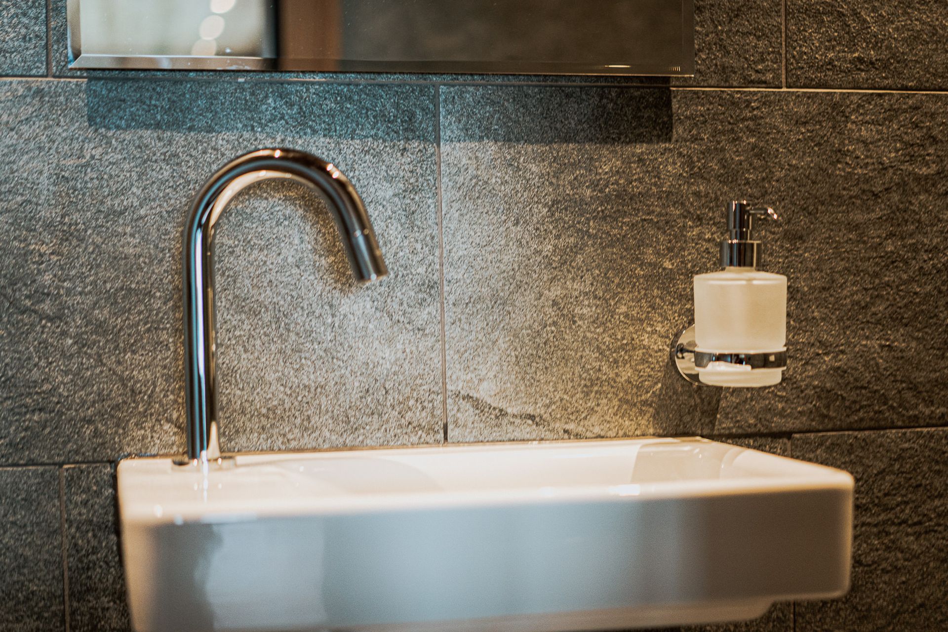 Ein Waschbecken mit Wasserhahn und Seifenspender.