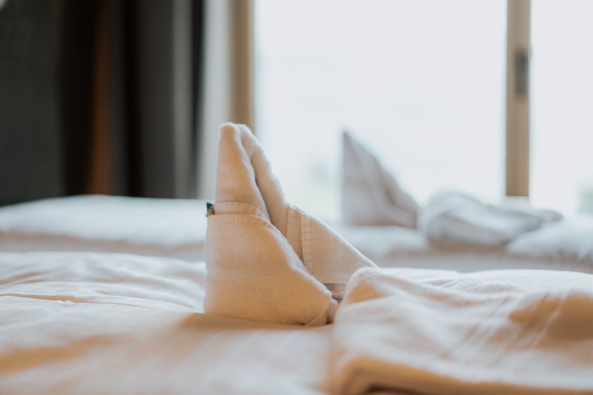 Eine Nahaufnahme eines Handtuchs auf einem Bett in einem Hotelzimmer.