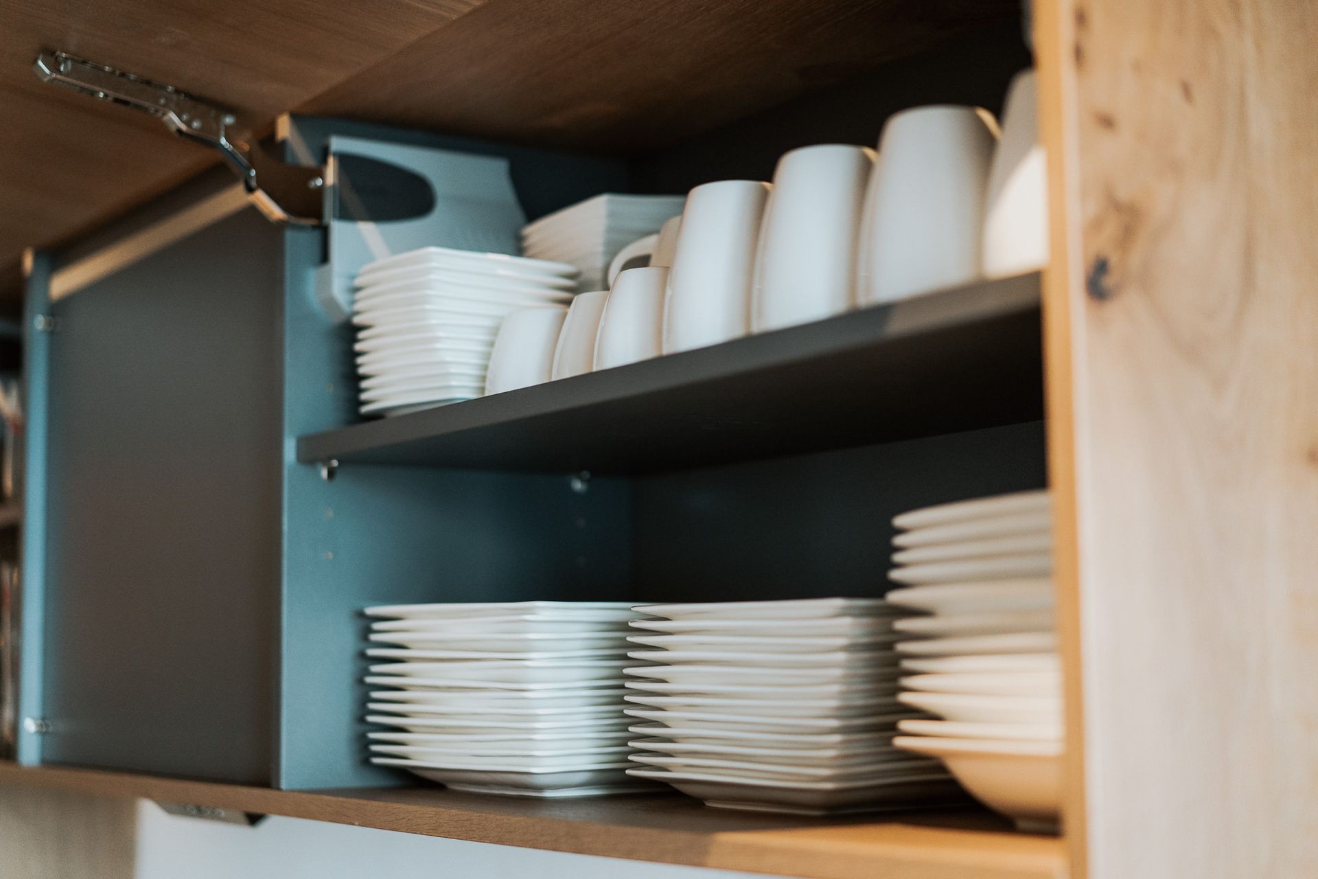 Ein Küchenschrank voller Teller und Tassen.