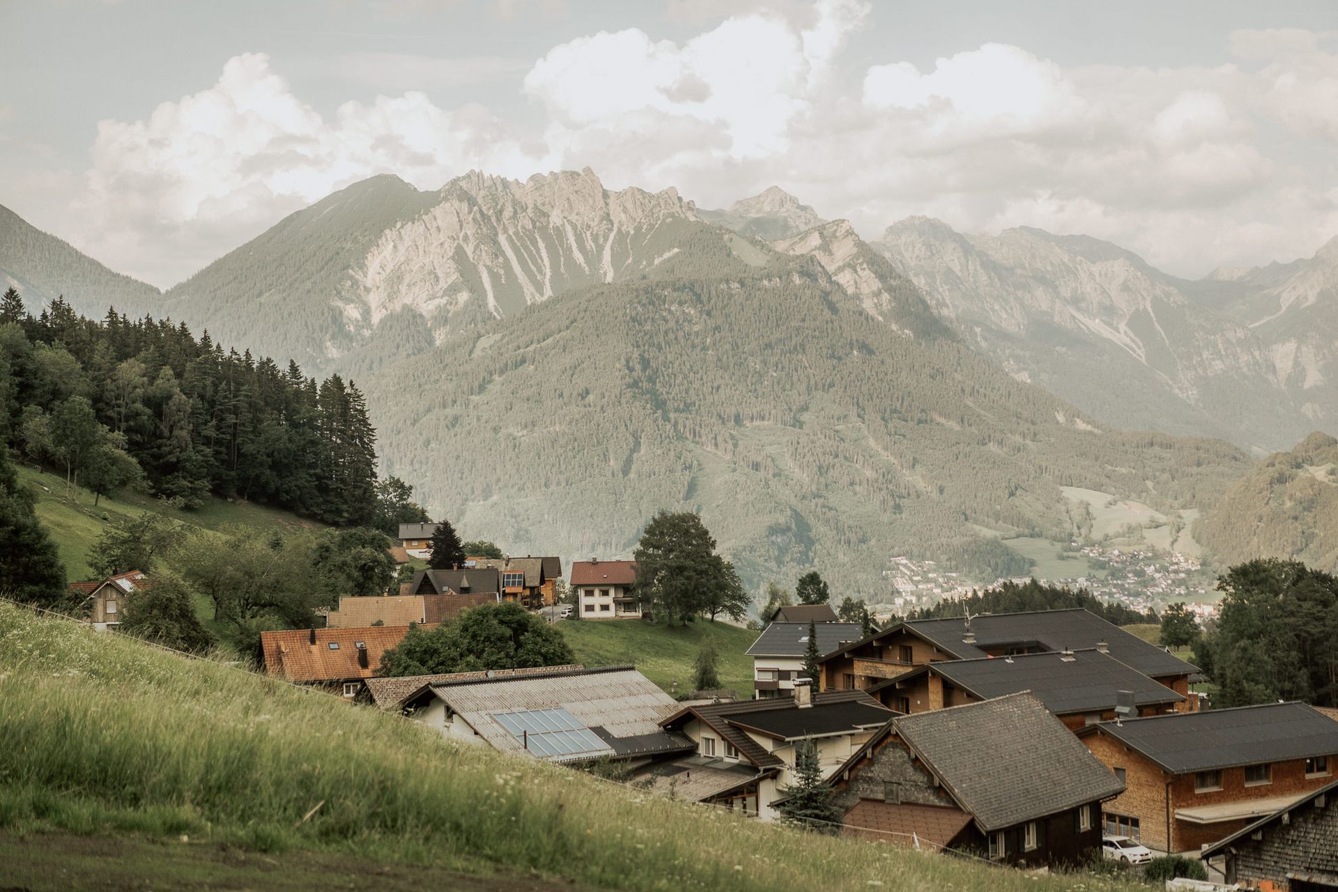 Ein kleines Dorf in den Bergen mit einem Berg im Hintergrund.