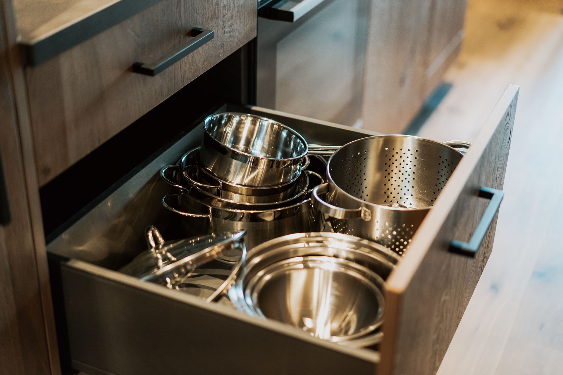Eine Schublade voller Töpfe und Pfannen in einer Küche.