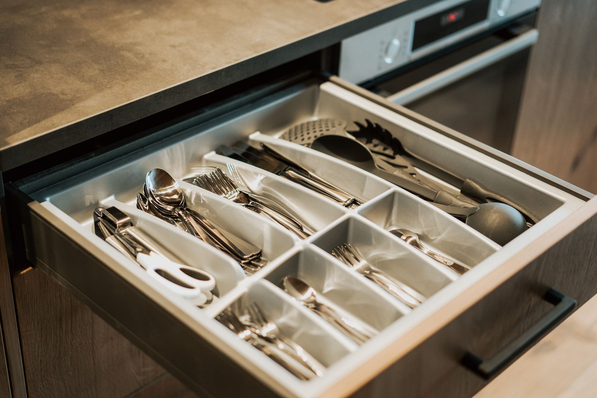 Eine Küchenschublade voller Besteck und Küchenutensilien.