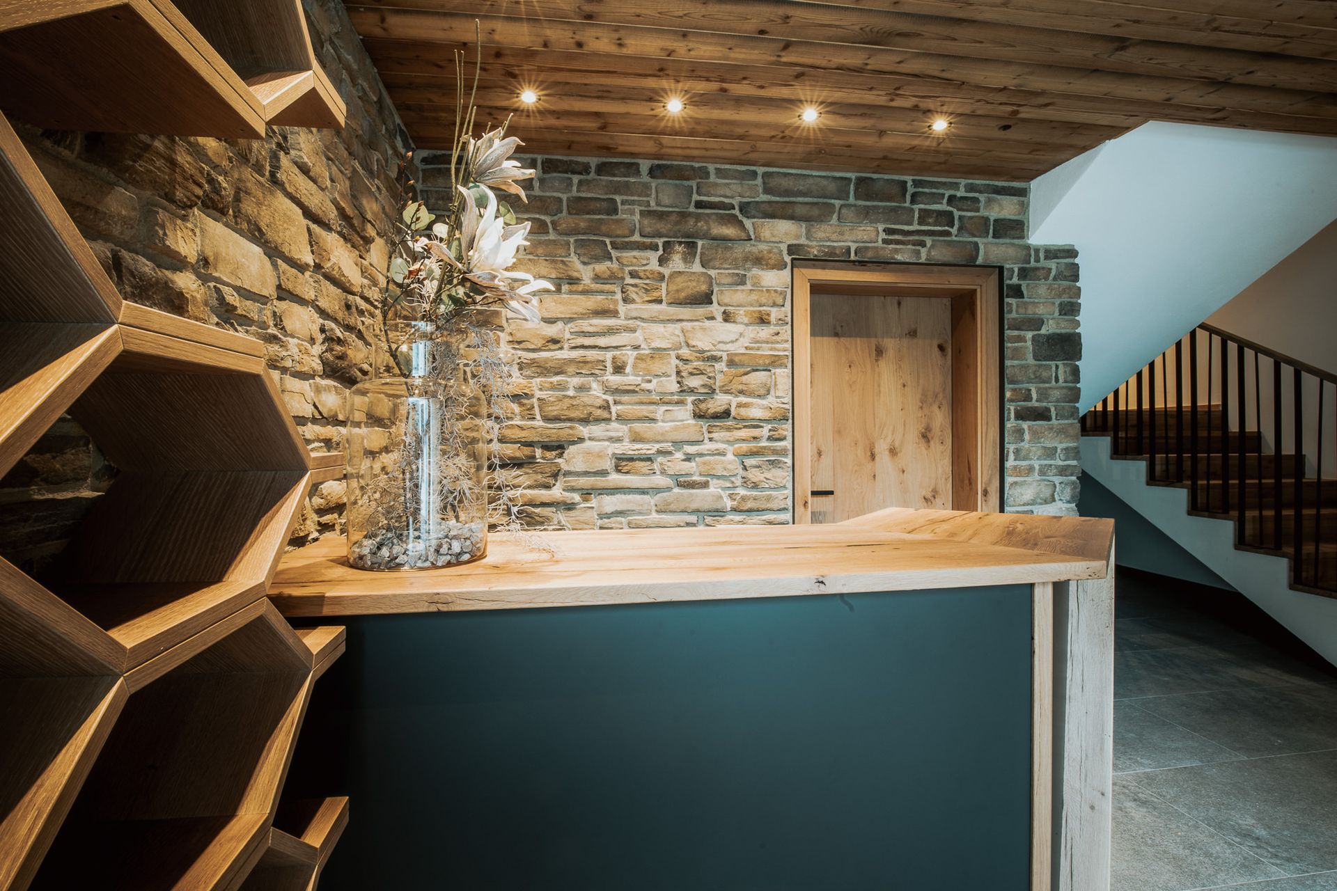 Eine Rezeption in einem Raum mit Steinwand und Treppe.