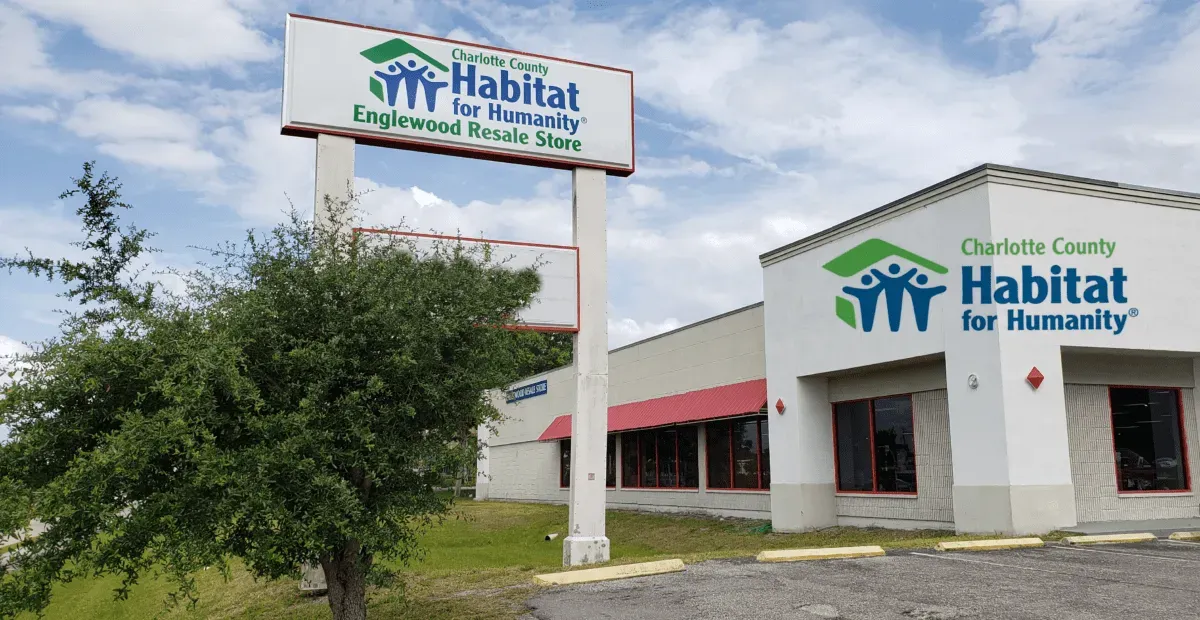 Habitat for Humanity building and sign in front of a blue sky.