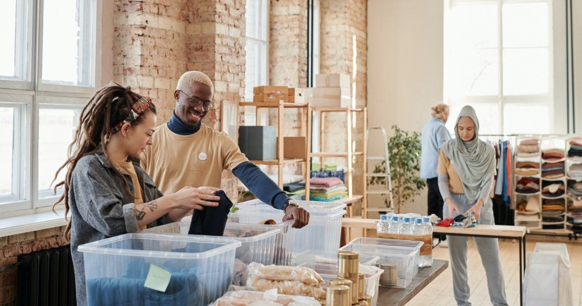 Volunteers sorting donations at a community center. People are organizing food and supplies, smiling.