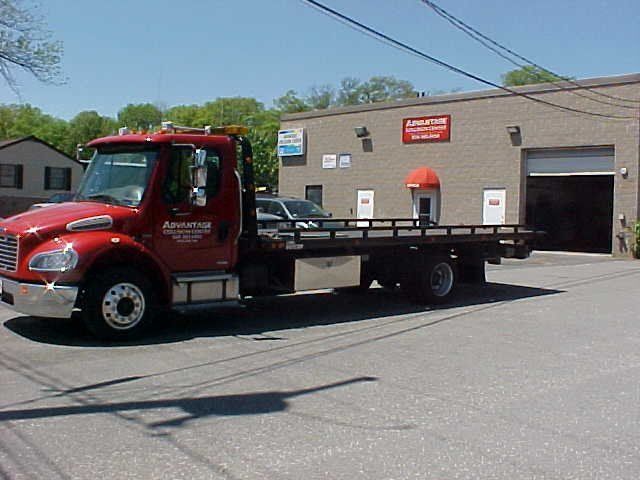 A red tow truck is parked in front of a building