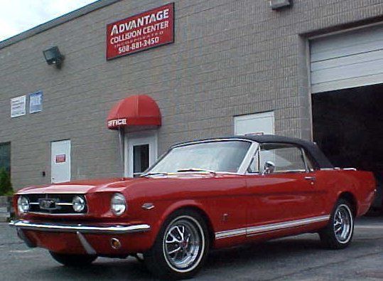 A red mustang is parked in front of the advantage collection center