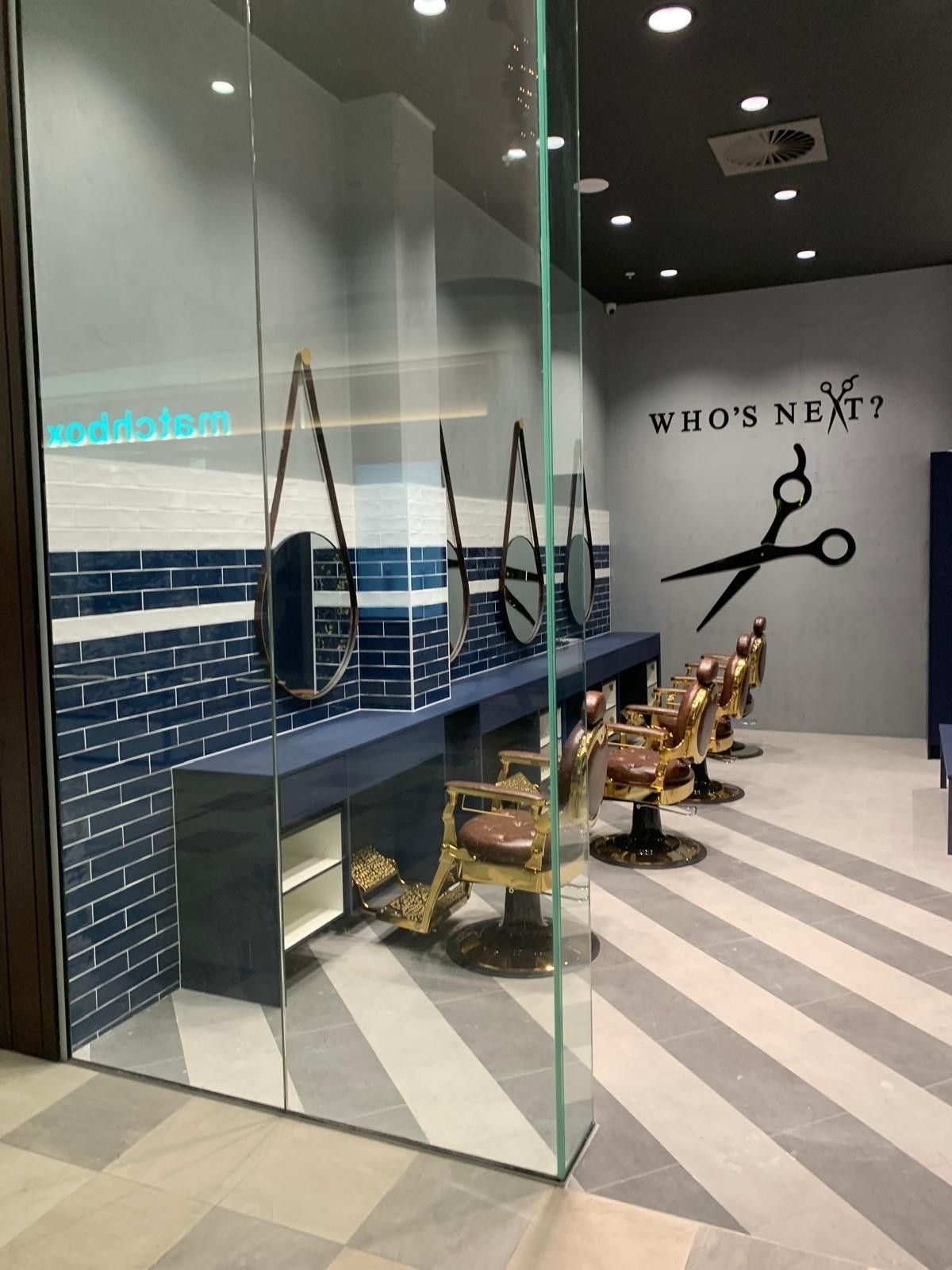 A high-angle view of a well-lit bakery or shop with wooden display tables and shelves stocked with various packaged goods.