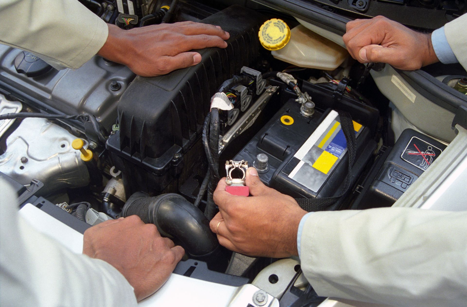 Technician installing a used car battery.