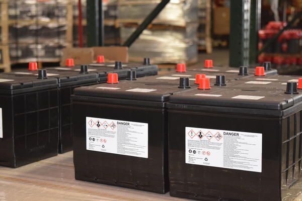 A bunch of batteries are sitting on a table in a warehouse.