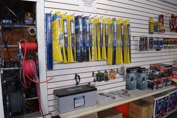 A bunch of wiper blades are hanging on a wall in a store.