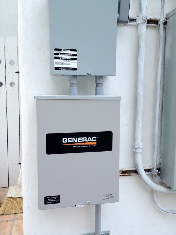 A Generac transfer switch and service disconnect box mounted on a white exterior wall.