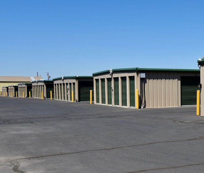 A man is holding a cardboard box in front of a storage unit.