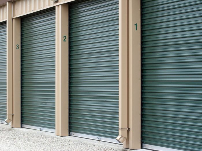 A row of green garage doors with numbers on them