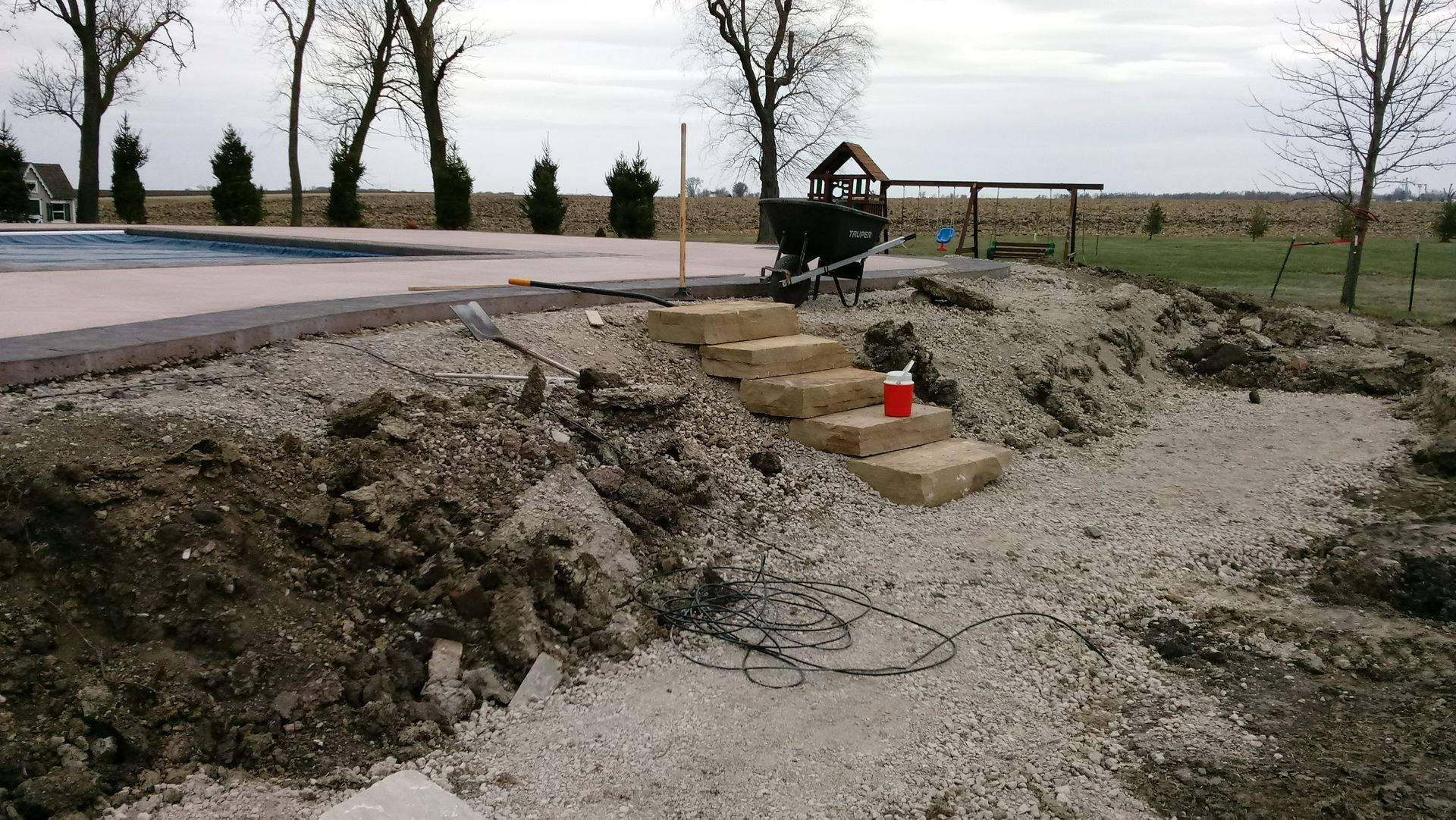 A staircase is being built next to a swimming pool.