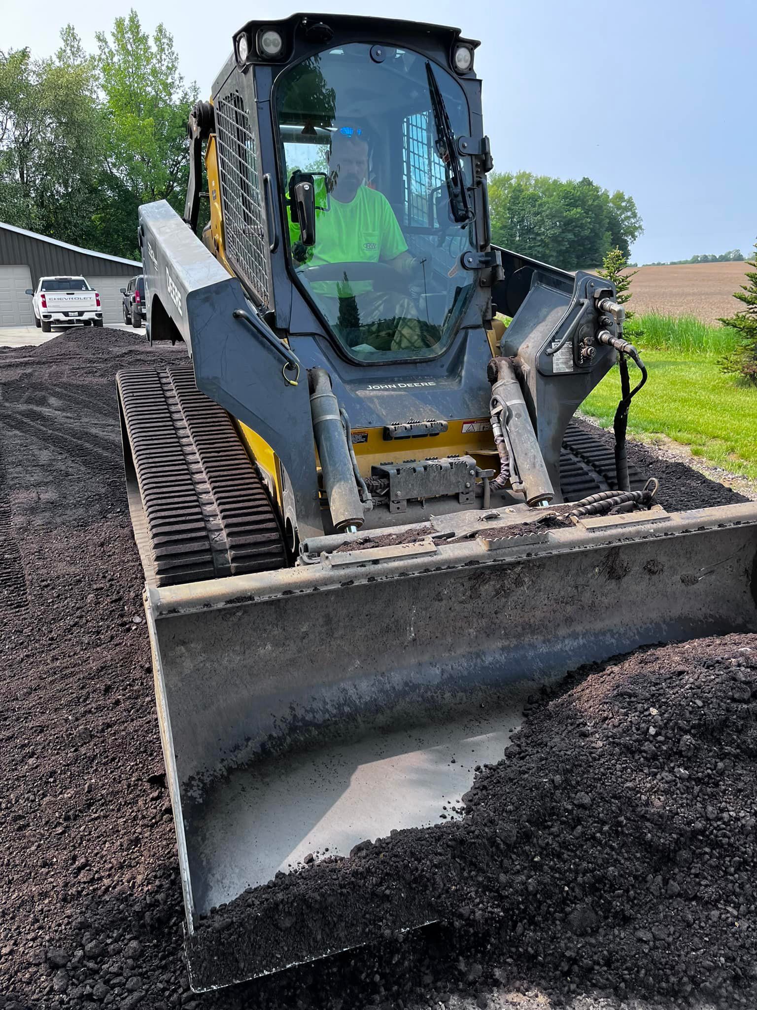 A man is driving a bulldozer on a pile of dirt.