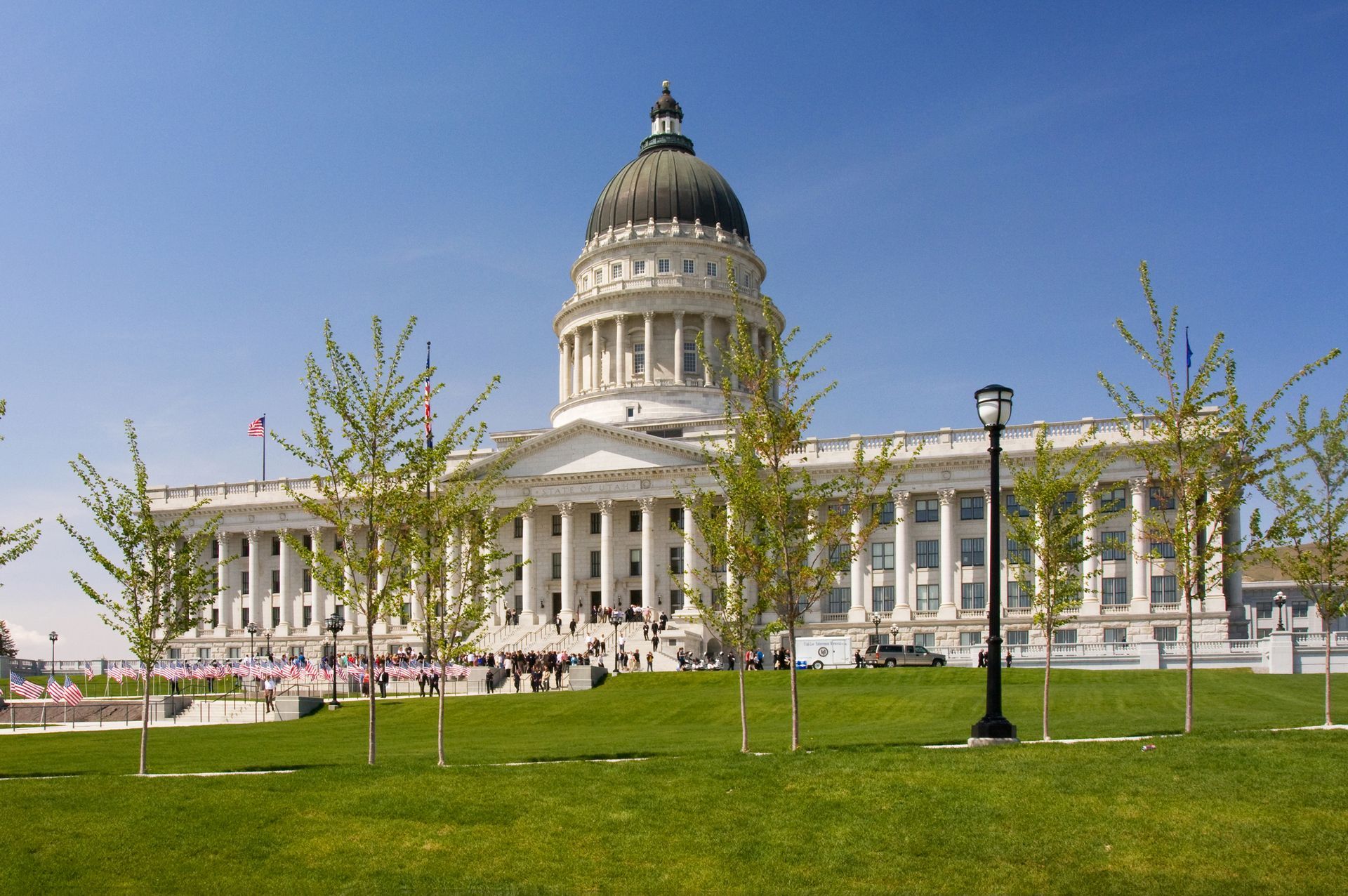 Utah State Capitol building with green lawn and blue sky.