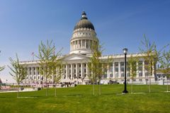 Utah State Capitol building with green lawn and blue sky.