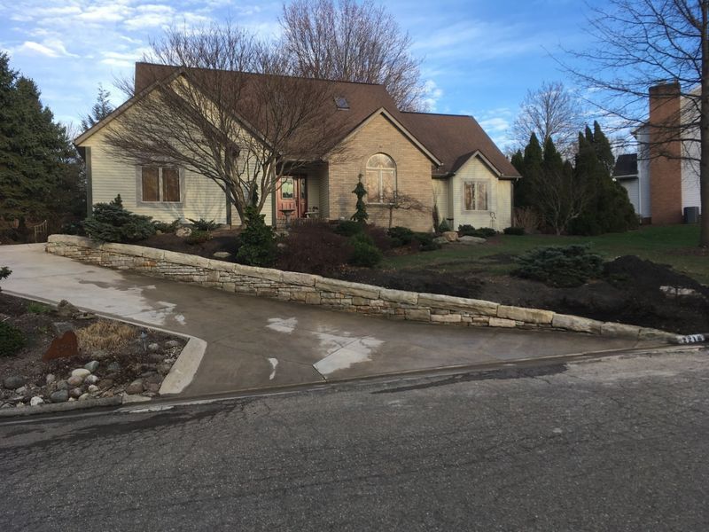 A large house with a stone wall in front of it
