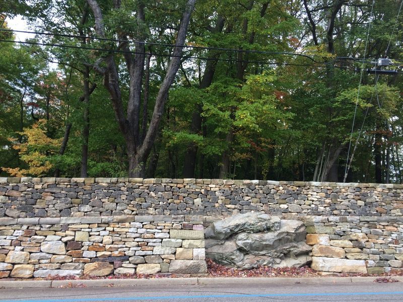 A large stone wall with trees in the background