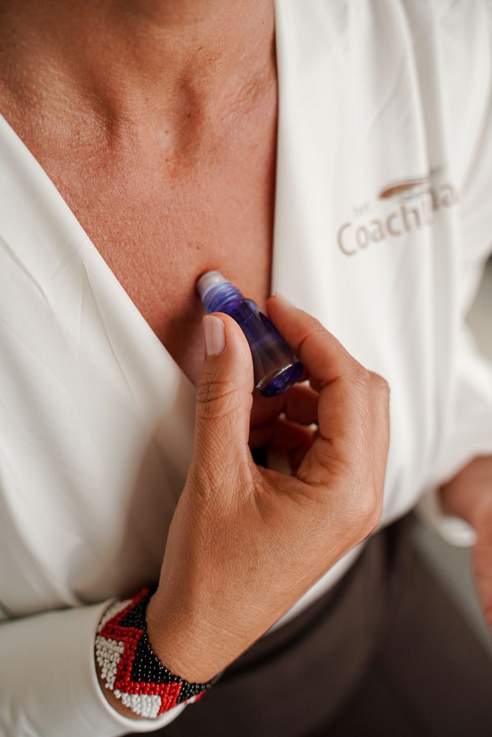 De rug van een persoon wordt van binnenuit aangeraakt door de hand van een andere persoon, mogelijk om troost of steun te bieden.