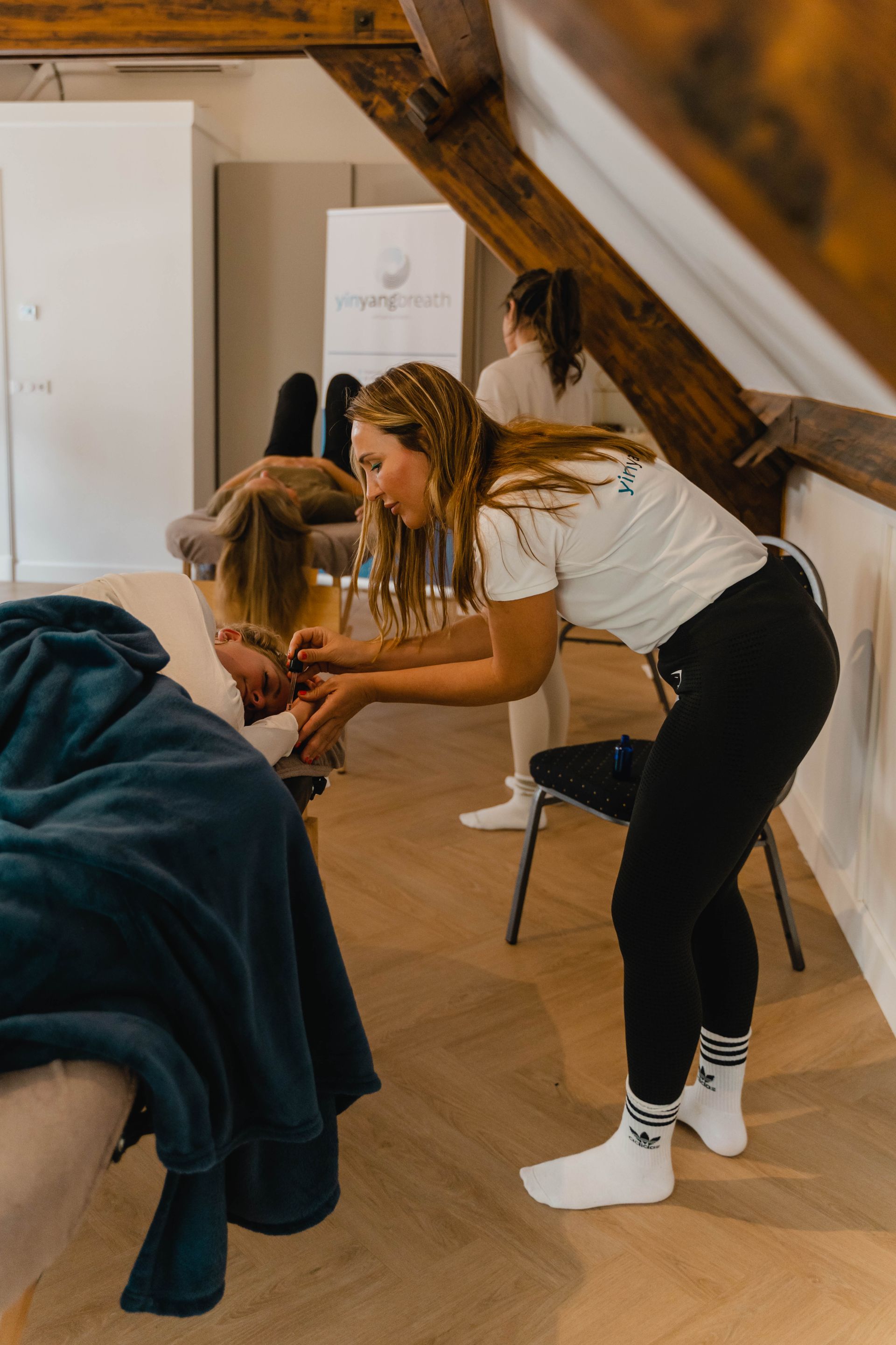 De rug van een persoon wordt van binnenuit aangeraakt door de hand van een andere persoon, mogelijk om troost of steun te bieden.