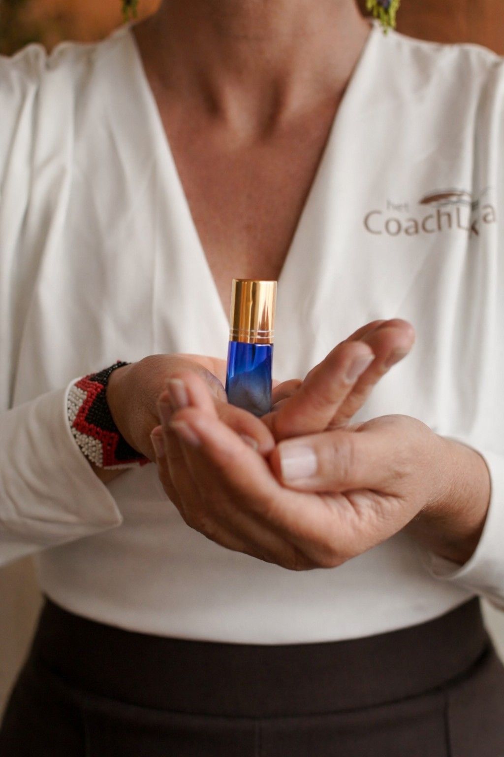 De rug van een persoon wordt van binnenuit aangeraakt door de hand van een andere persoon, mogelijk om troost of steun te bieden.