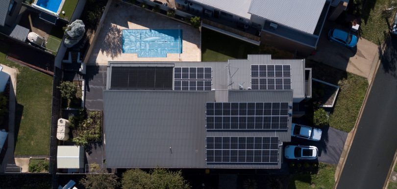 An aerial view of a house with solar panels on the roof.
