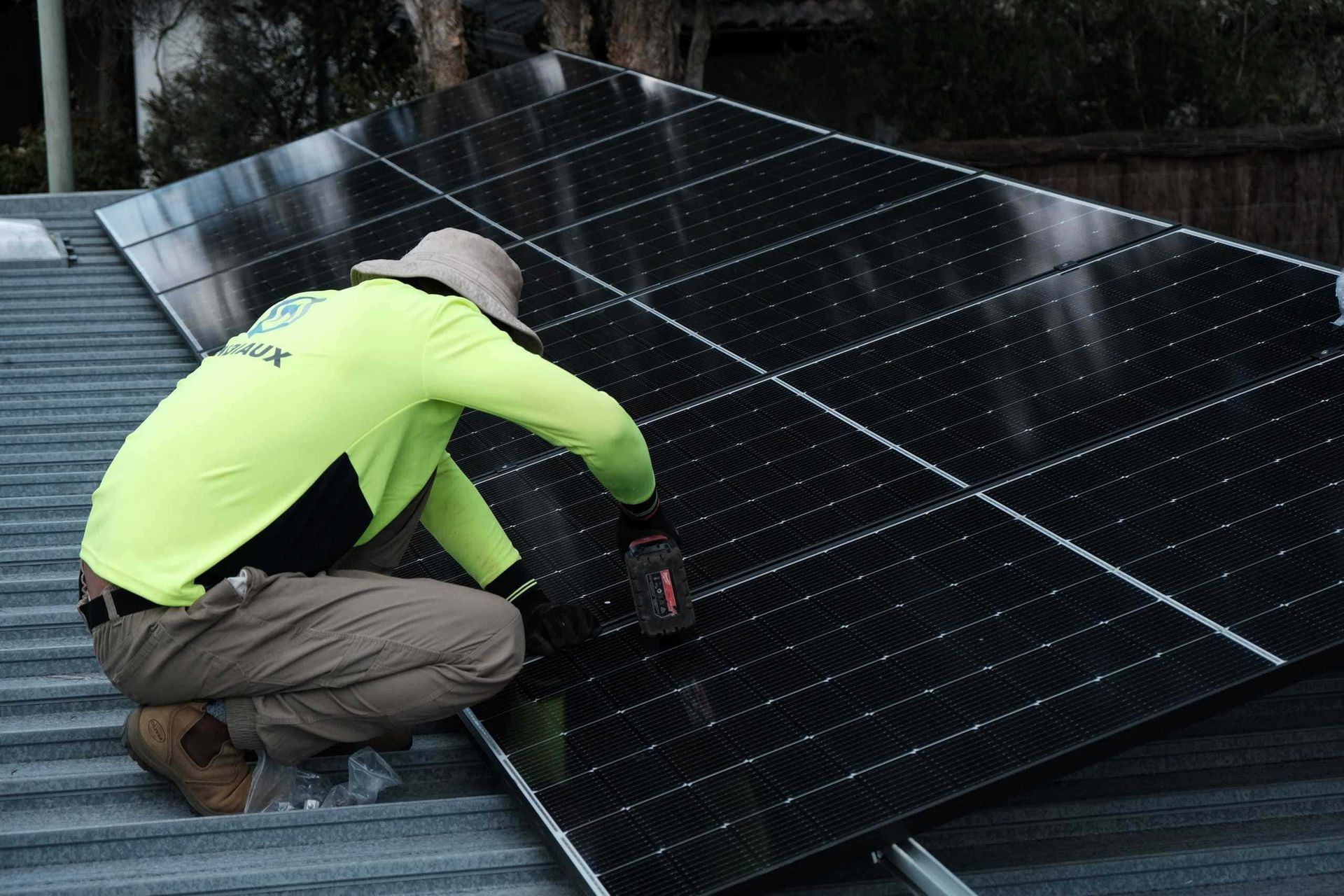 A man is installing solar panels on a roof.