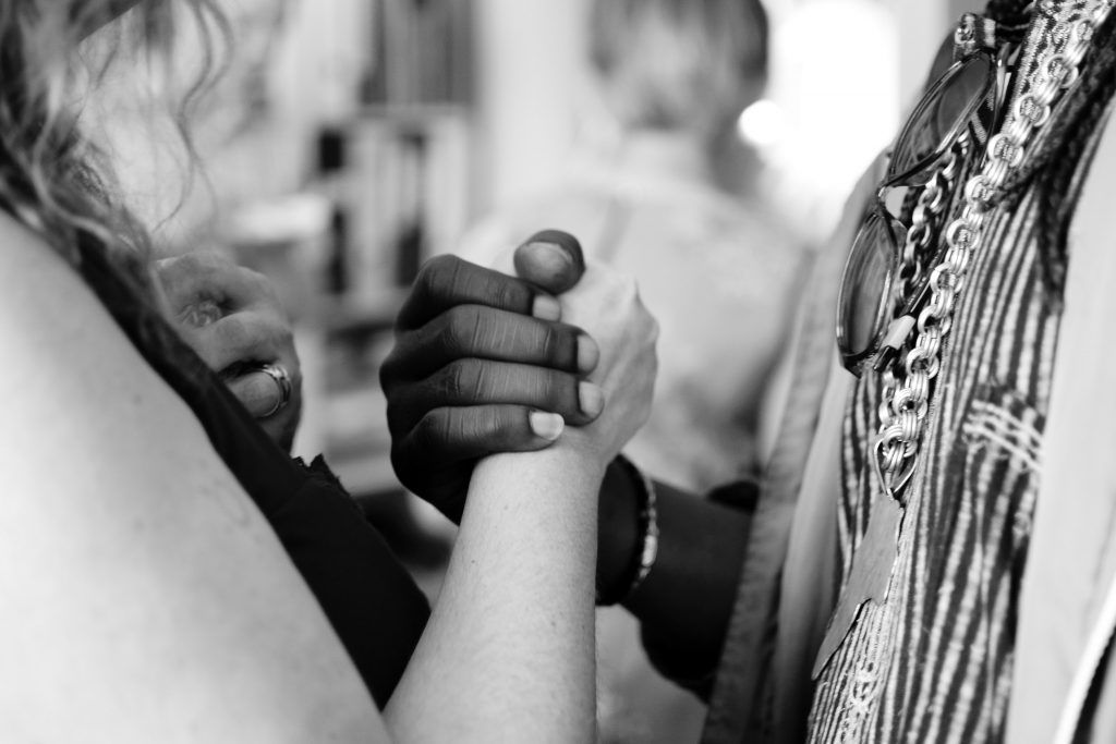 Two women are holding hands in a black and white photo.