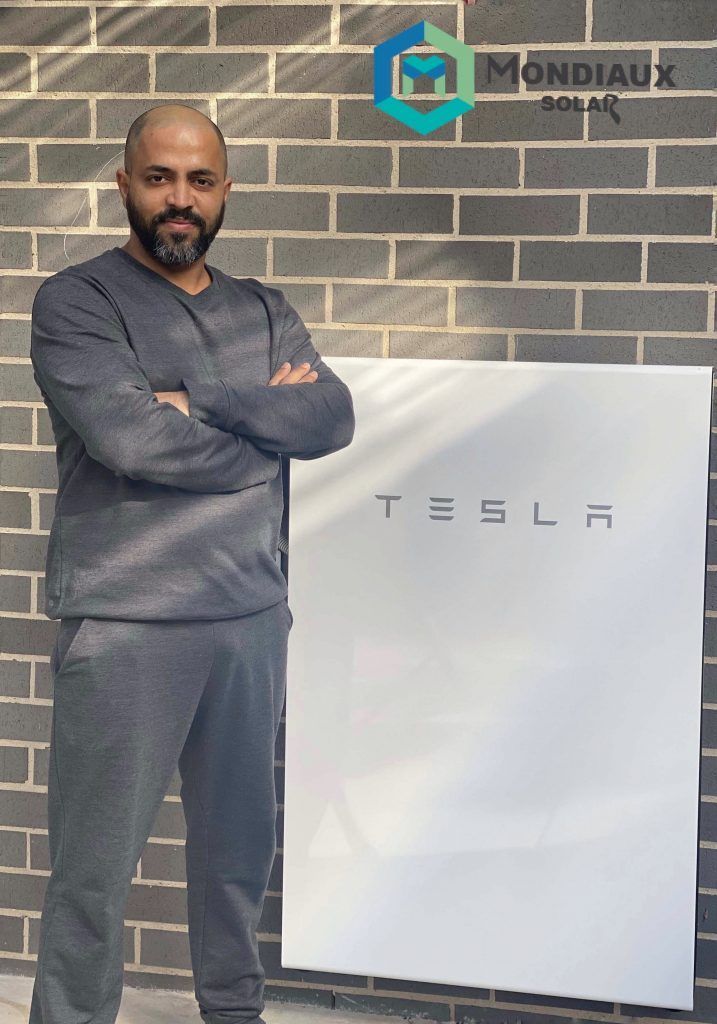 A man standing in front of a tesla wall
