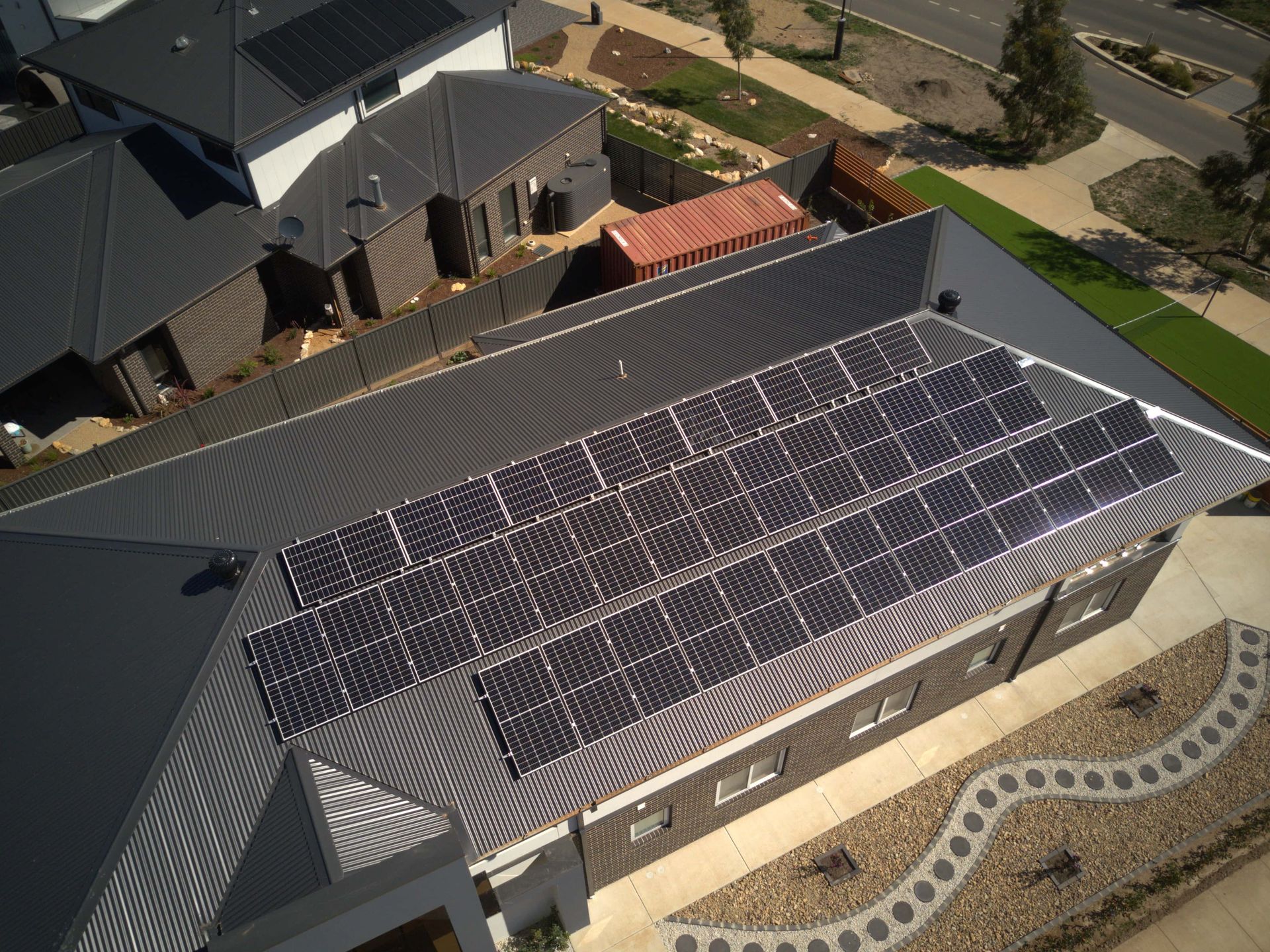 An aerial view of a house with solar panels on the roof