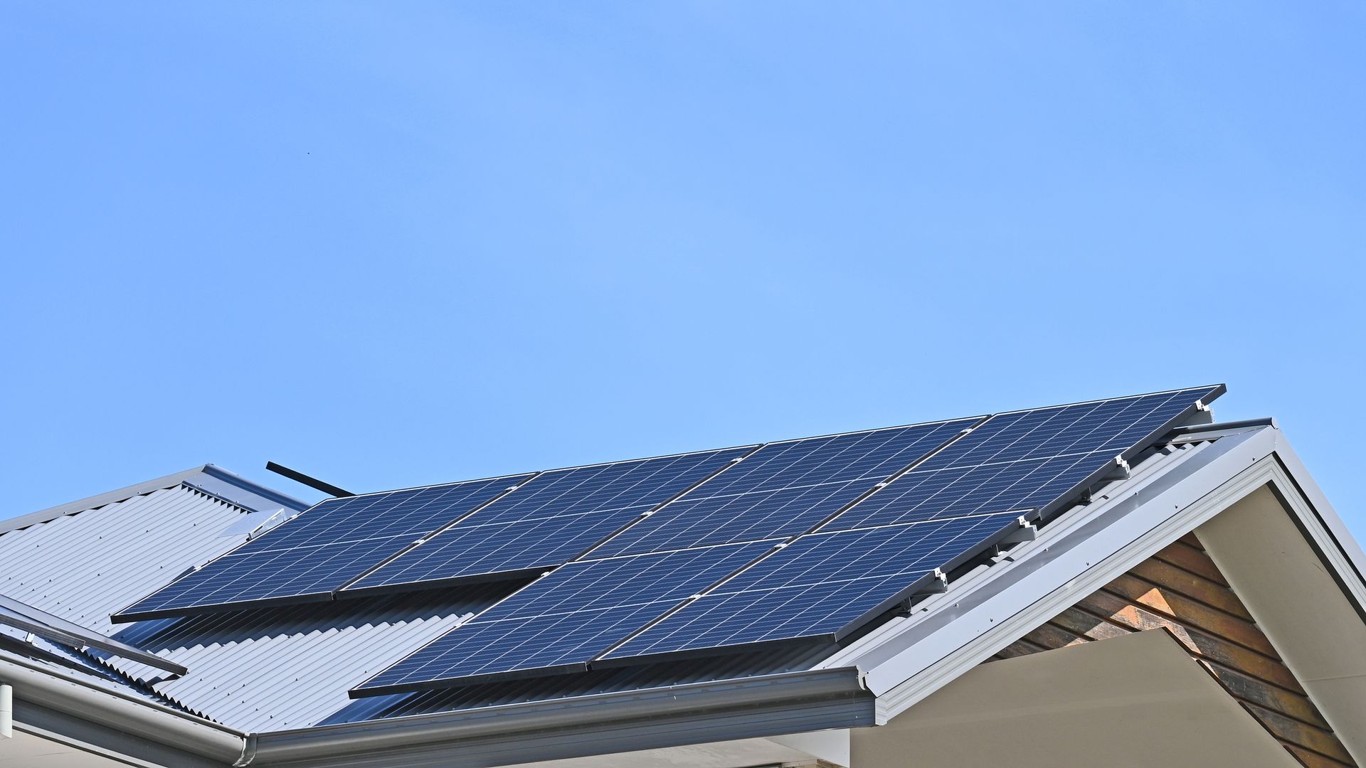 There are two solar panels on the roof of a house.