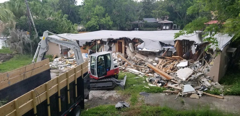 A house is being demolished by a bulldozer.