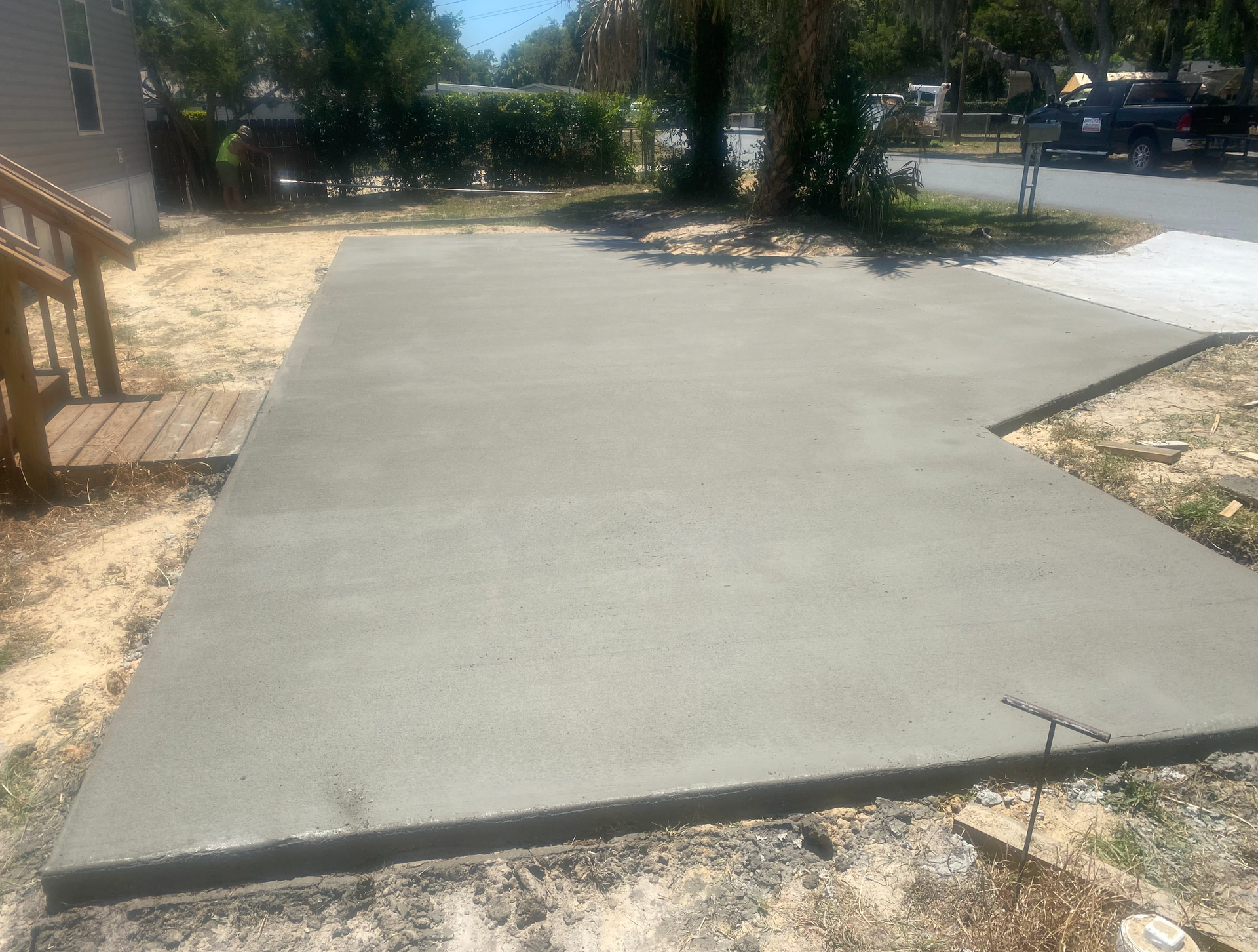 A concrete driveway is being built in front of a house.