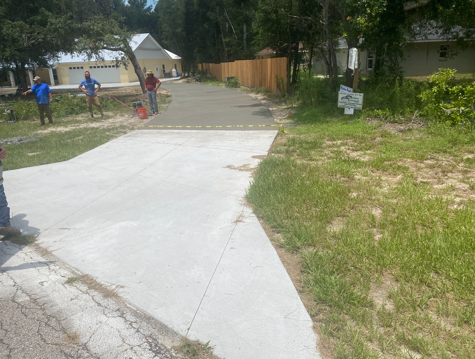 A group of people are walking down a concrete driveway