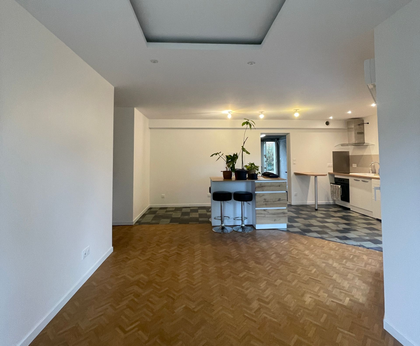 Chambre d'hôtel moderne avec un lit, un canapé et une table avec un ordinateur portable. 