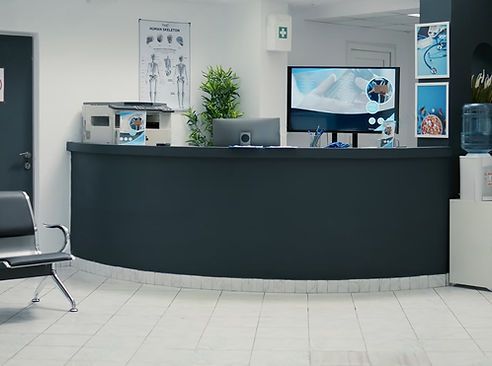 Steam cleaner nozzle spraying carpet next to a blue office partition, with a metal bracket at the corner.