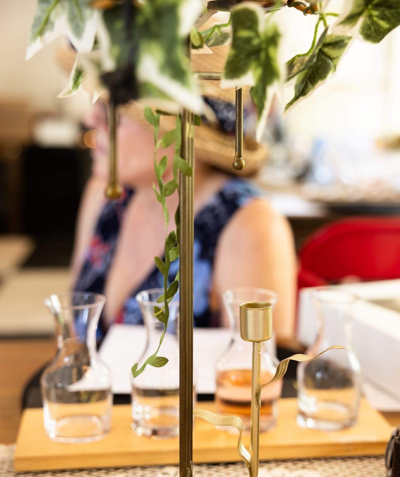 Golden candle holder with clear carafes, person in background blurred.