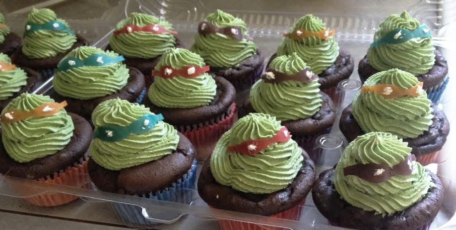 Teenage Mutant Ninja Turtle cupcakes with green frosting and colored bandanas.