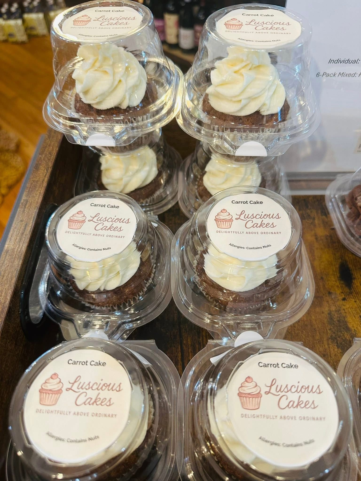 Cupcakes in clear plastic containers with white frosting and 