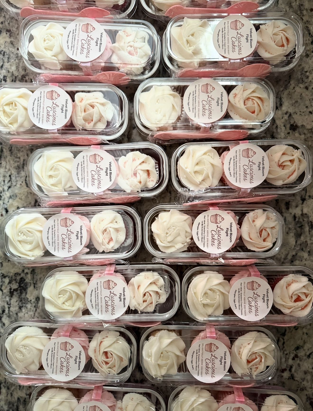 Packaged meringue cookies in clear plastic containers with pink and white frosting, ready for sale.