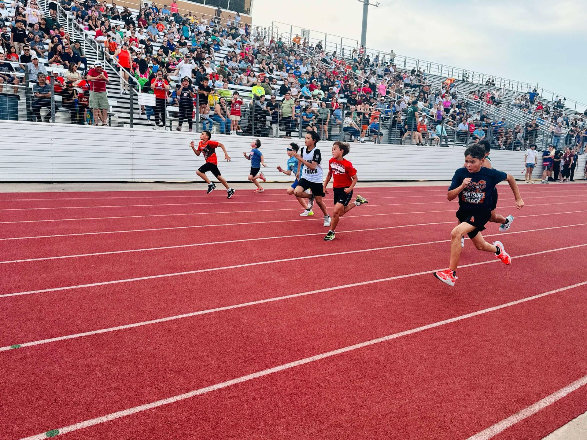 Baseball player sliding into home plate, catcher in front. Blue and gold uniforms, action shot.