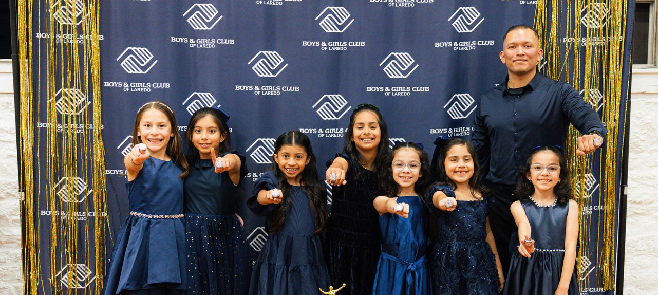 Baseball player sliding into home plate, catcher in front. Blue and gold uniforms, action shot.