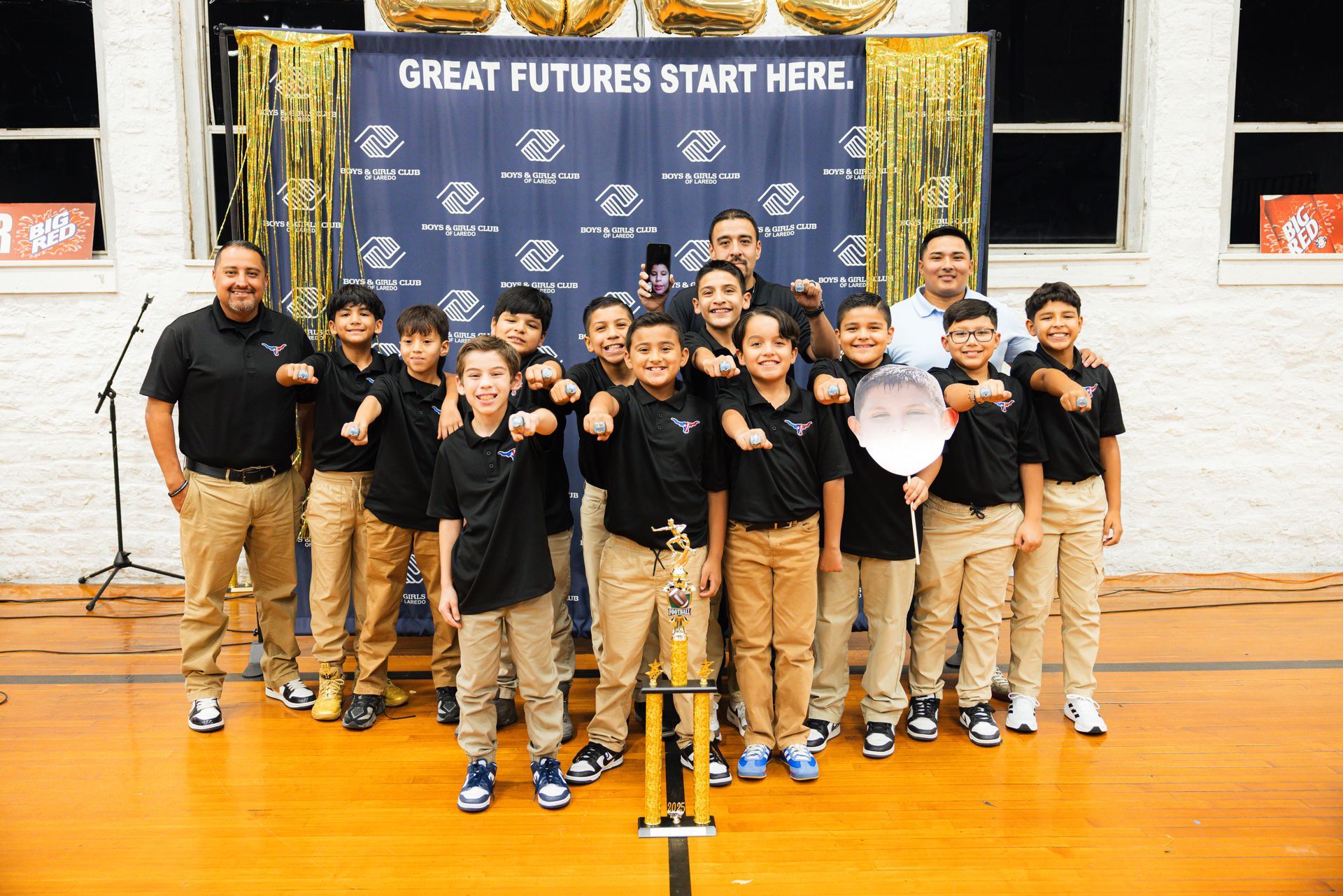 Baseball glove with ball on green grass, with blurred baseballs in the background.