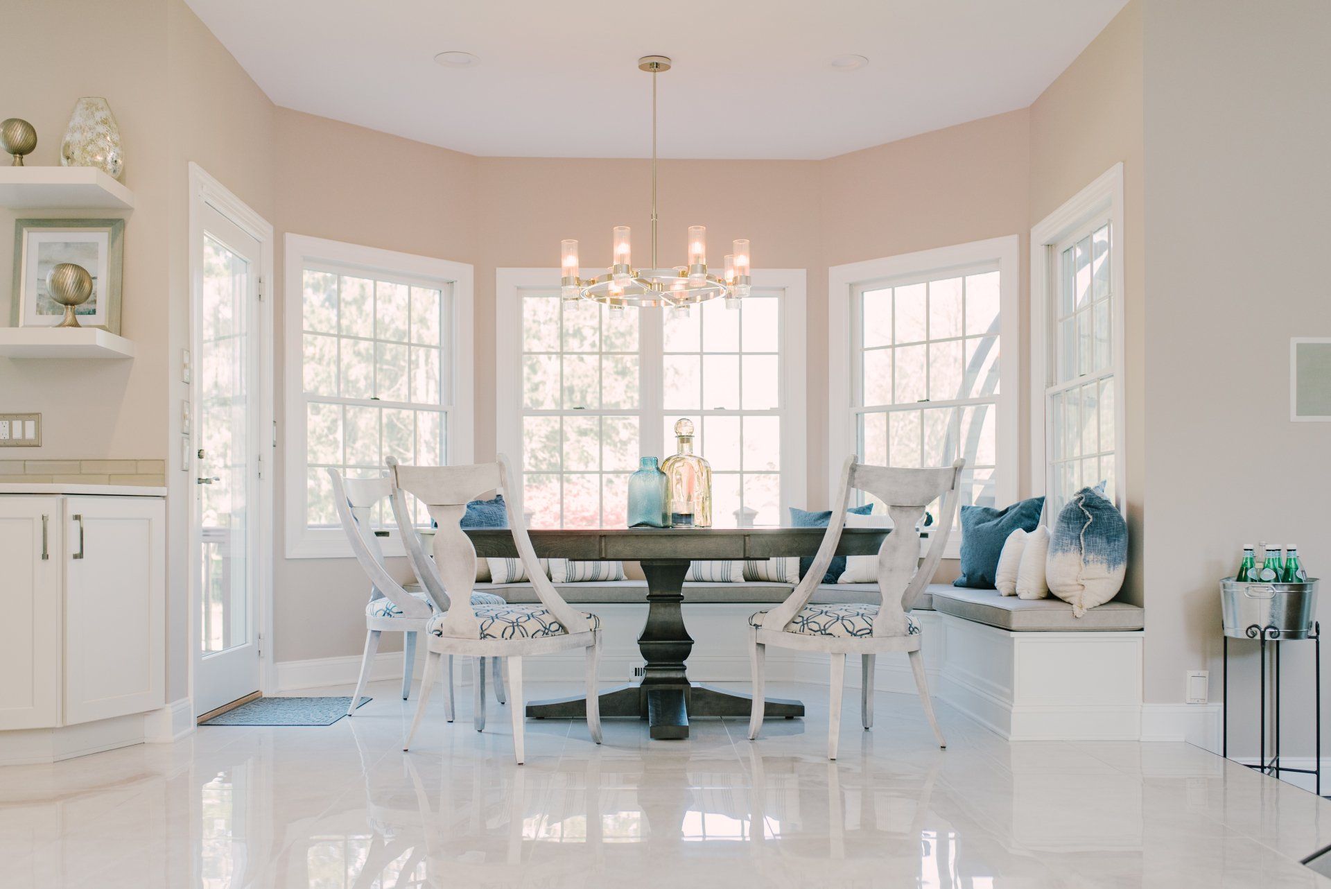 A dining room with a table and chairs and a window seat.