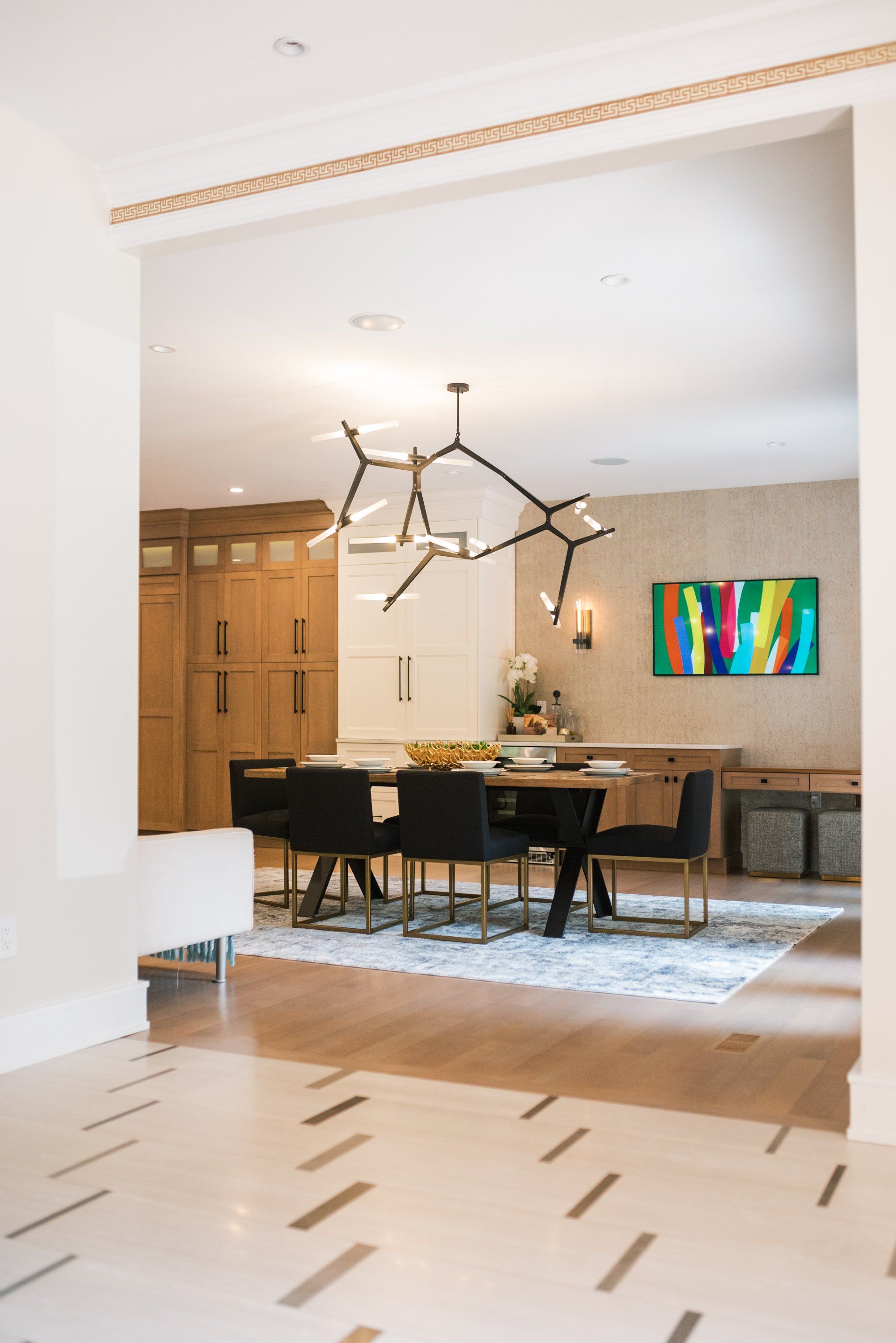 A dining room with a table and chairs and a painting on the wall