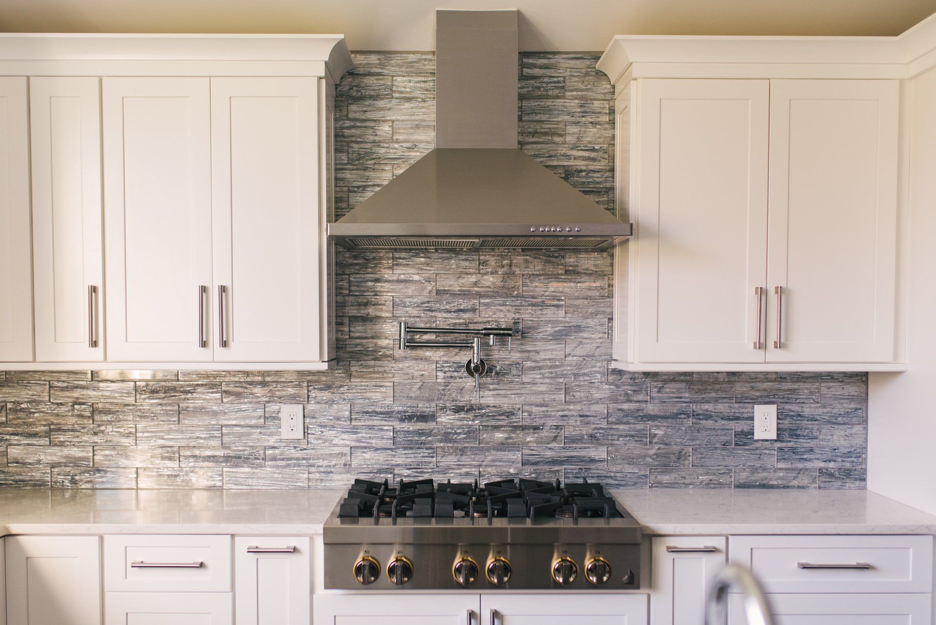 A kitchen with white cabinets and a stove top oven