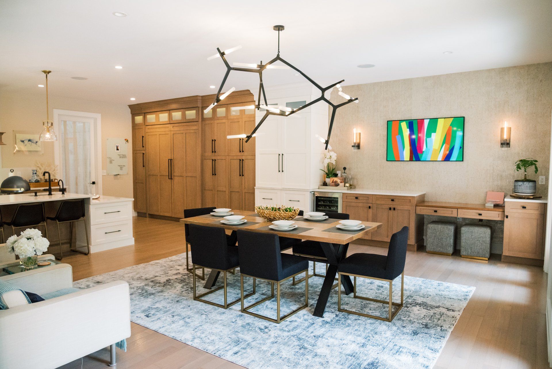 A dining room with a table and chairs and a chandelier hanging from the ceiling.