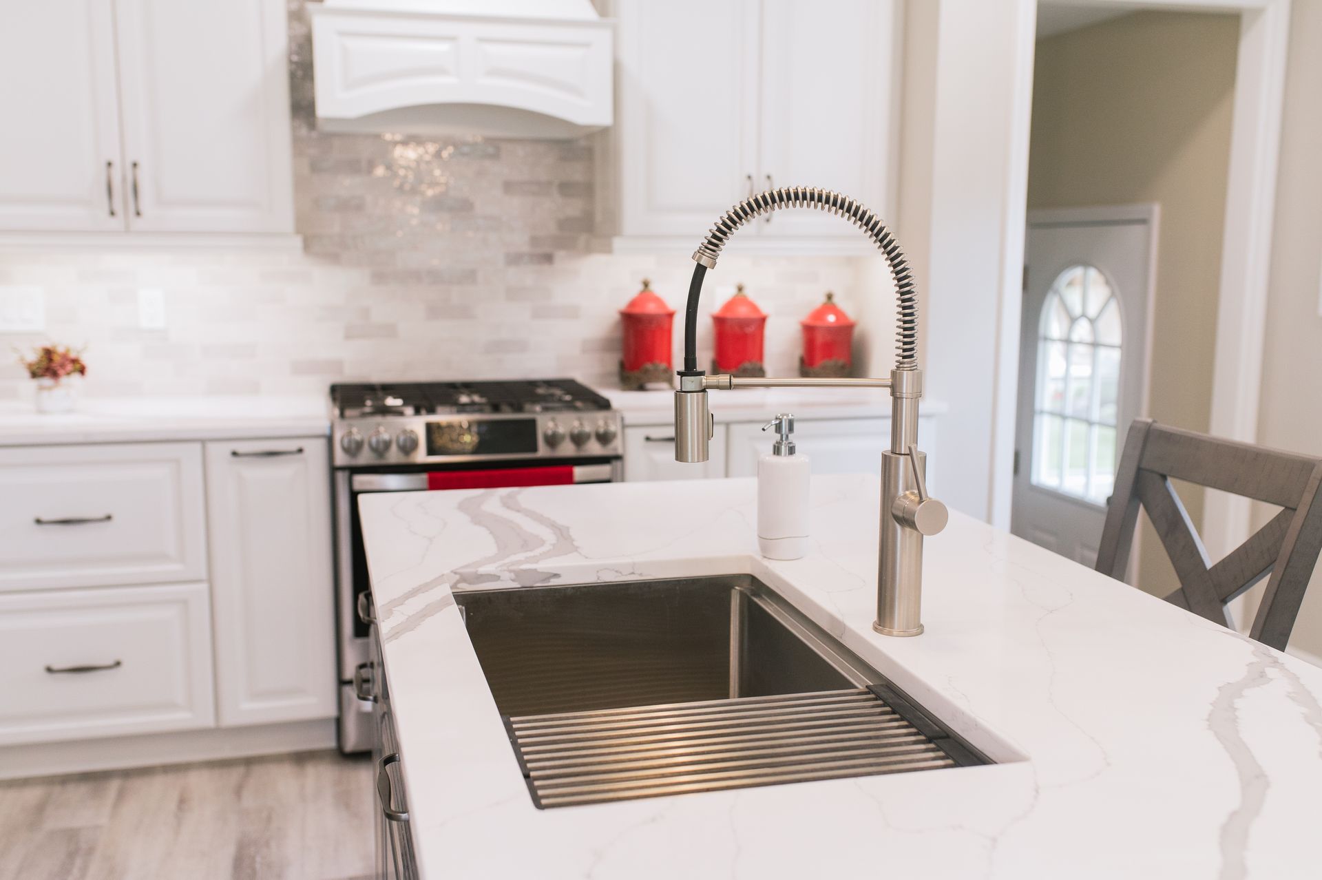 A kitchen with white cabinets and a stainless steel sink.